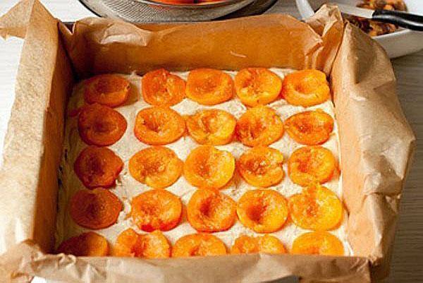 выложить в форму жидкое тесто и размороженные абрикосы